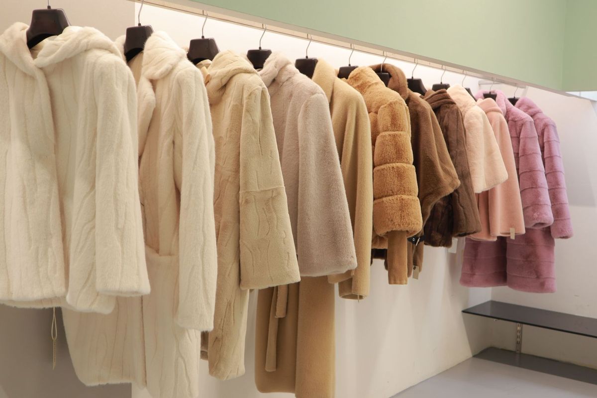 Giacche in pelliccia ed ecopelliccia color avorio nello showroom.