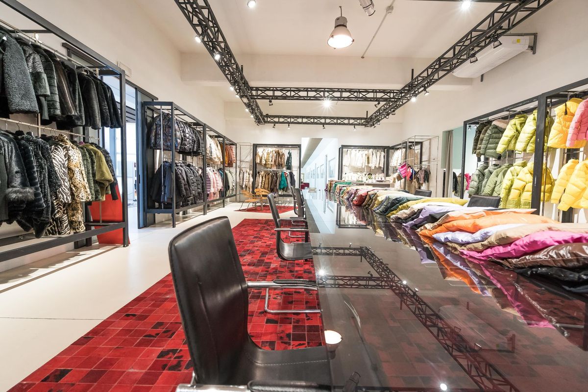 Sala dello showroom GIUPEL con i banchi di presentazione e le rastrelliere dei capi.