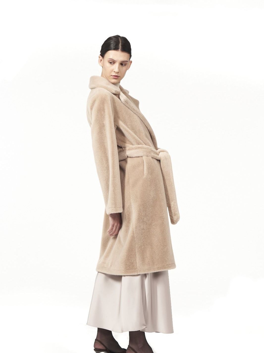 Modella con cappotto lungo color cammello con cintura, collezione SimplyVee.