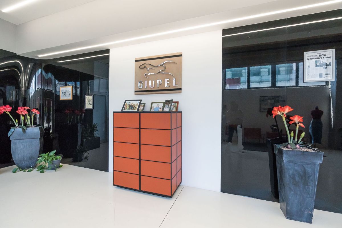 Ingresso della sede GIUPEL in Via Arezzo: l’insegna con il cavallo, il bancone arancione e le vetrine dello showroom.